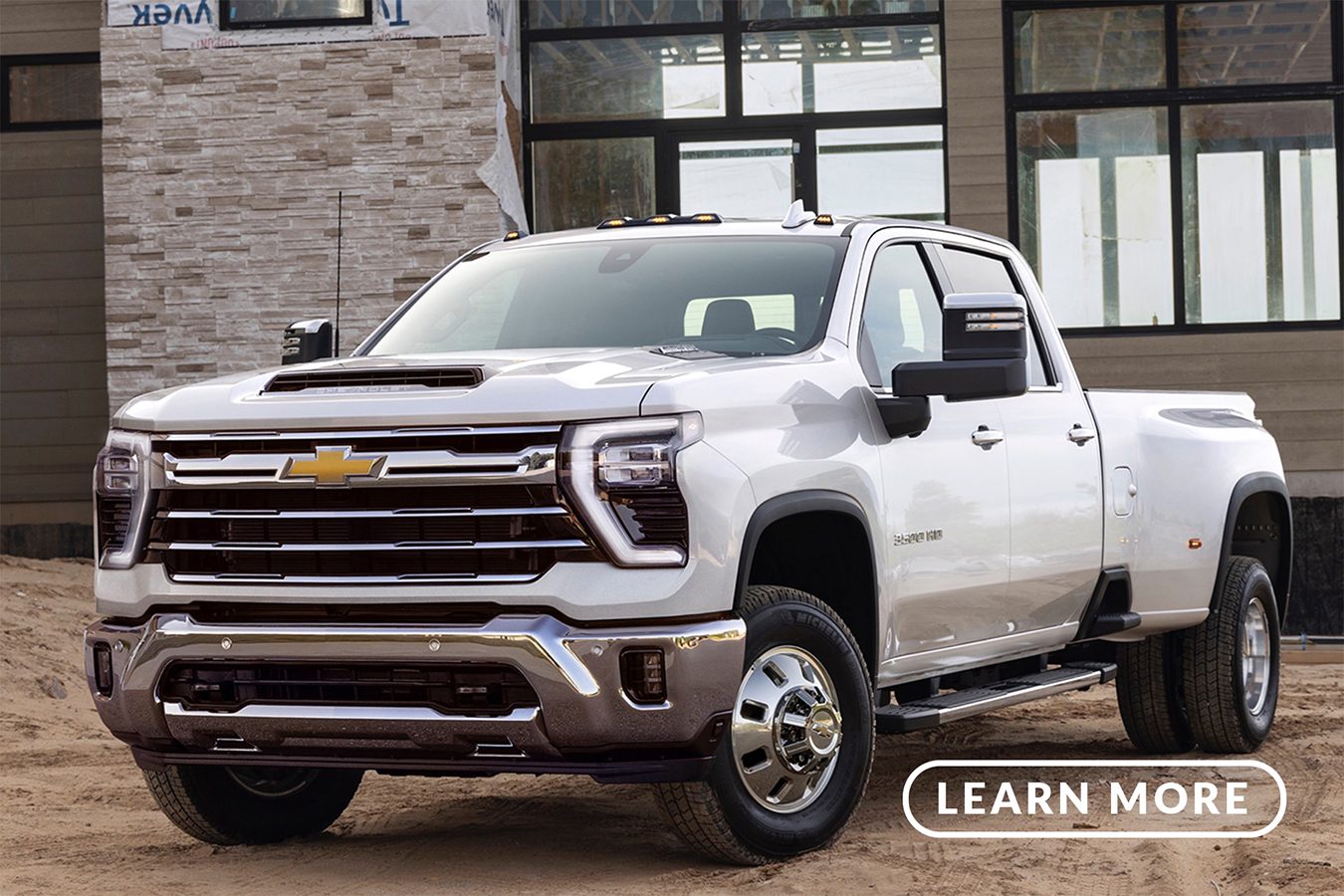 A white chevrolet silverado parked in front of a building.