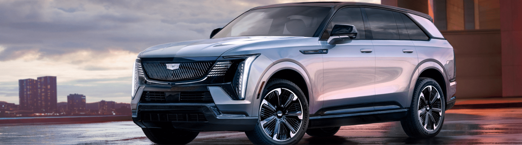 The 2020 cadillac escalade is parked in front of a city.
