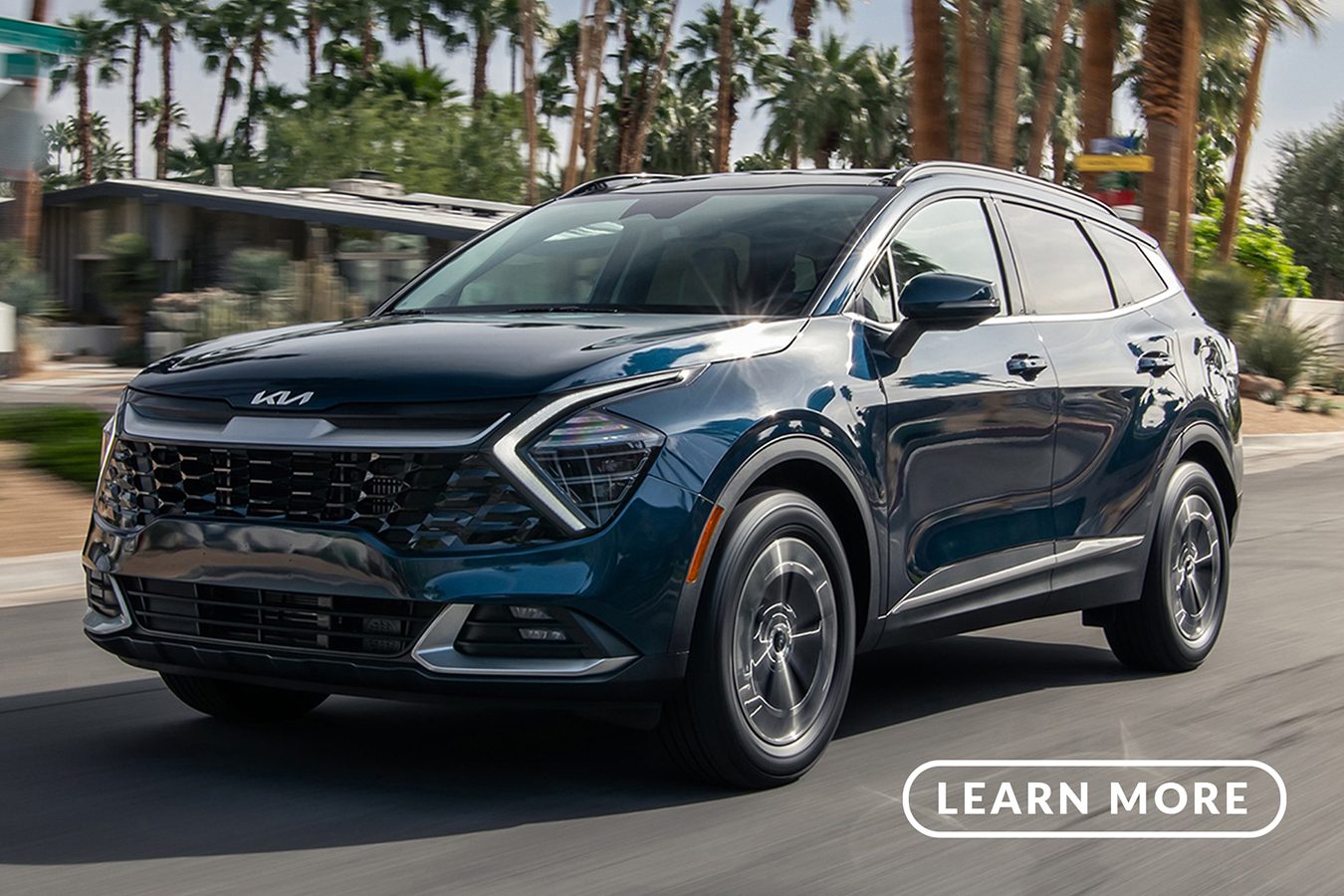 A blue 2020 KIA driving down a street with palm trees.