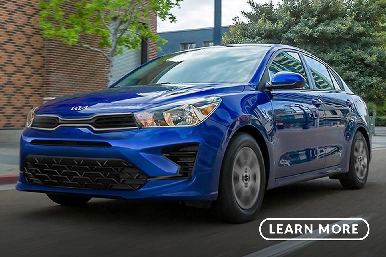 A blue 2019 kia rio driving down the street.