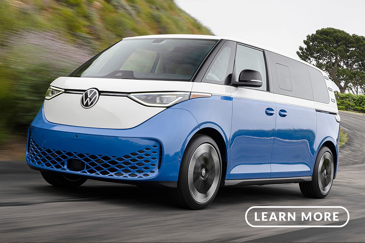 A blue and white volkswagen e-car driving down a road.